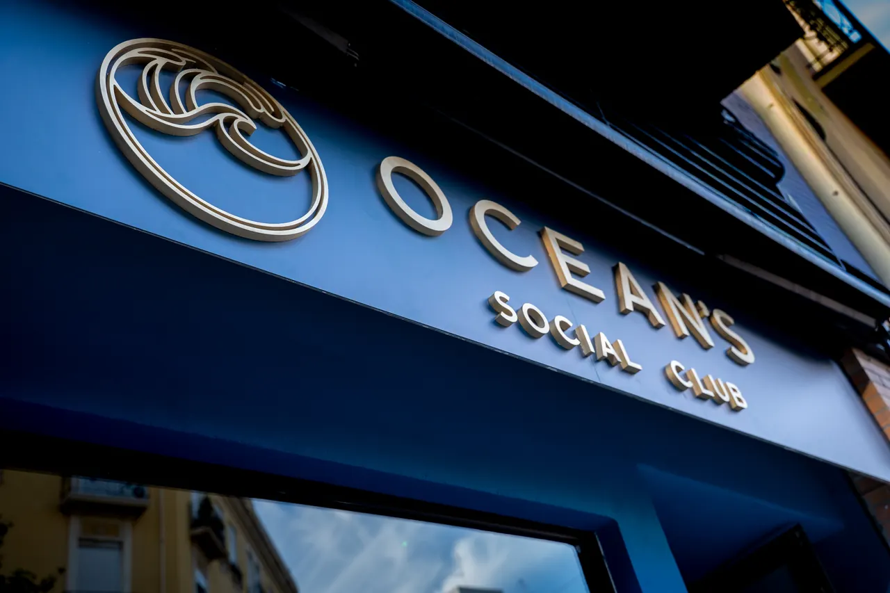 The blue front of Oceans, with gold OCEAN’S SOCIAL CLUB lettering and the wave logo above the entrance